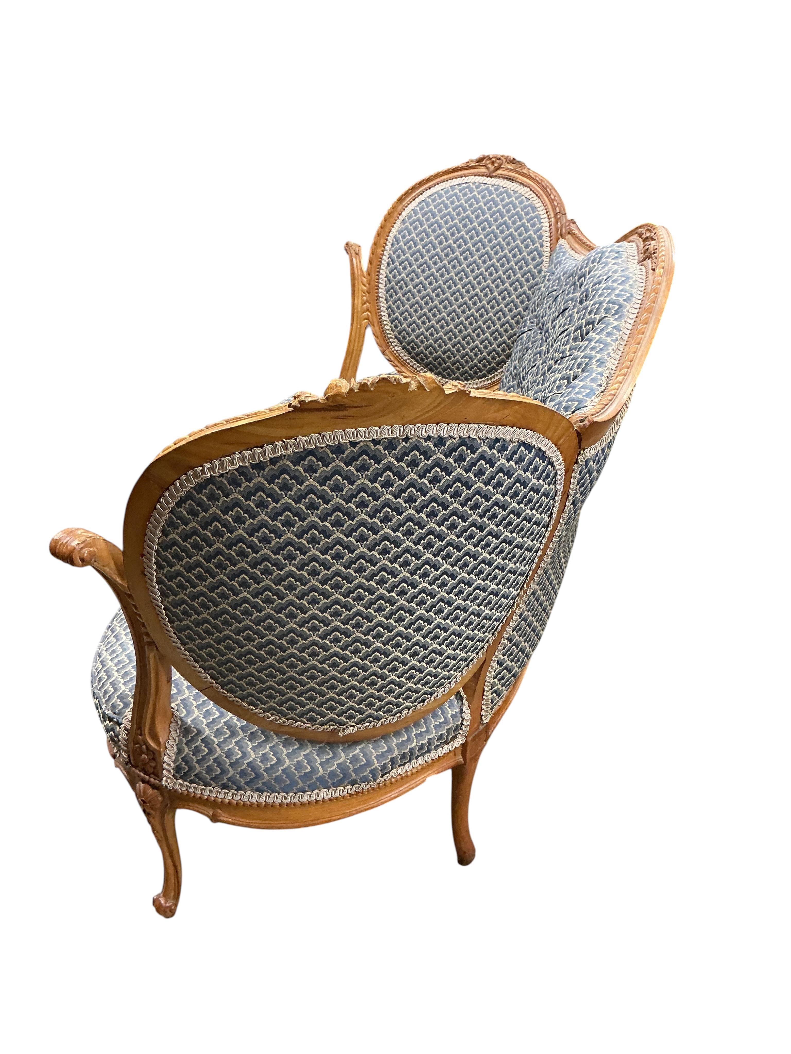 A late 19th / early 20th century French upholstered carved walnut upholstered settee, width 136cm, depth 68cm, height 86cm